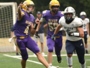 Columbia River quarterback Adam Watts, left, zips a pass on the run while being chased by Skyview’s Gavin Poffenroth, right, on Saturday at Kiggins Bowl in Vancouver.