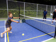 Amara Erickson, 5, left, smiles as she plays her first game of pickleball July 2 at Lakeridge Playfield in Seattle. Pickleball is the official sport of the state of Washington. The game was invented on Bainbridge Island in 1965.