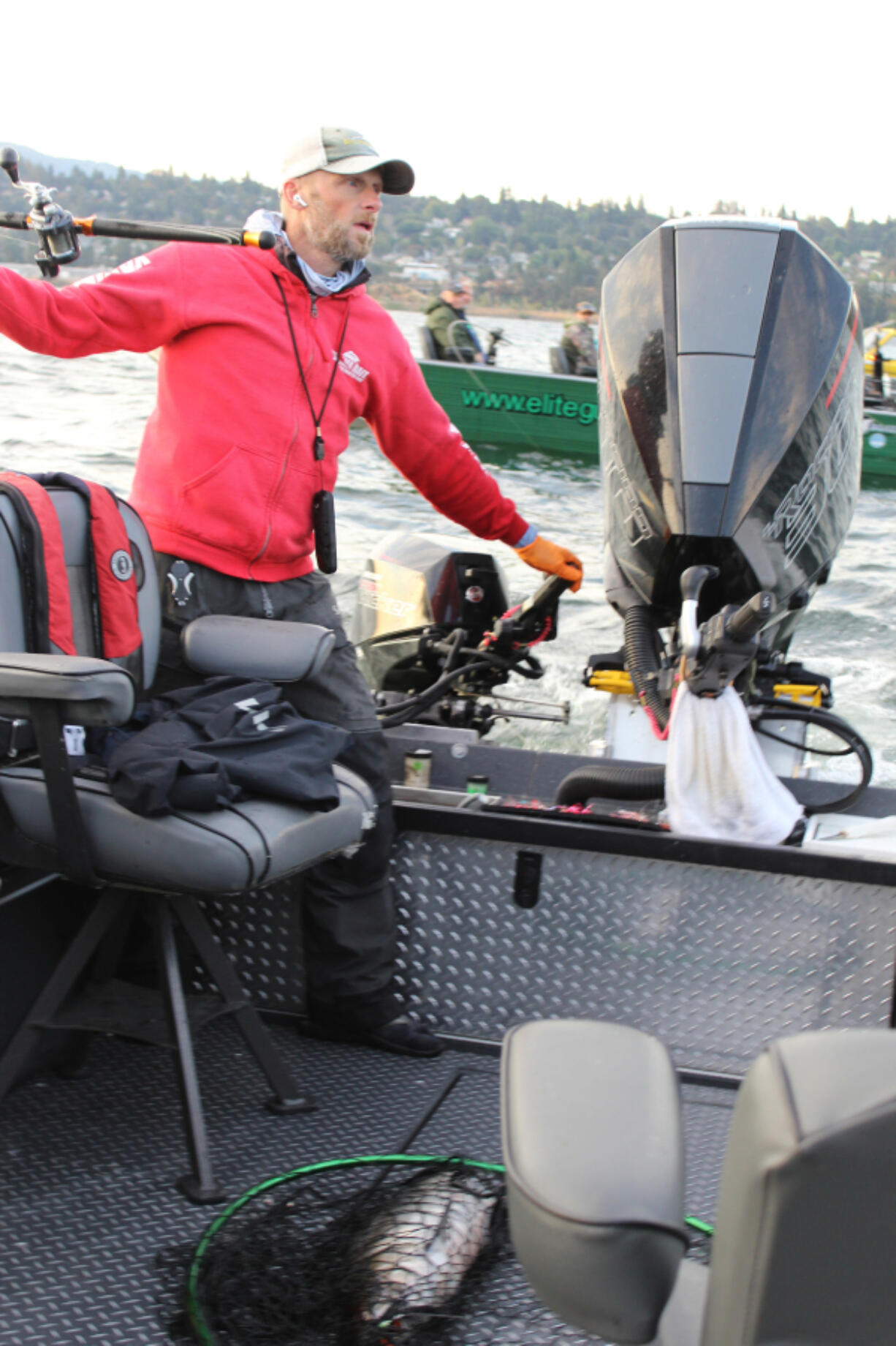 After netting a Chinook, (lower picture), fishing guide Bill Monroe Jr juggles guides his boat between other boats crammed into the tight confines of the mouth of the White Salmon River on the Columbia. All the while he must orchestrate his clients actions to avoid tangling the lines.