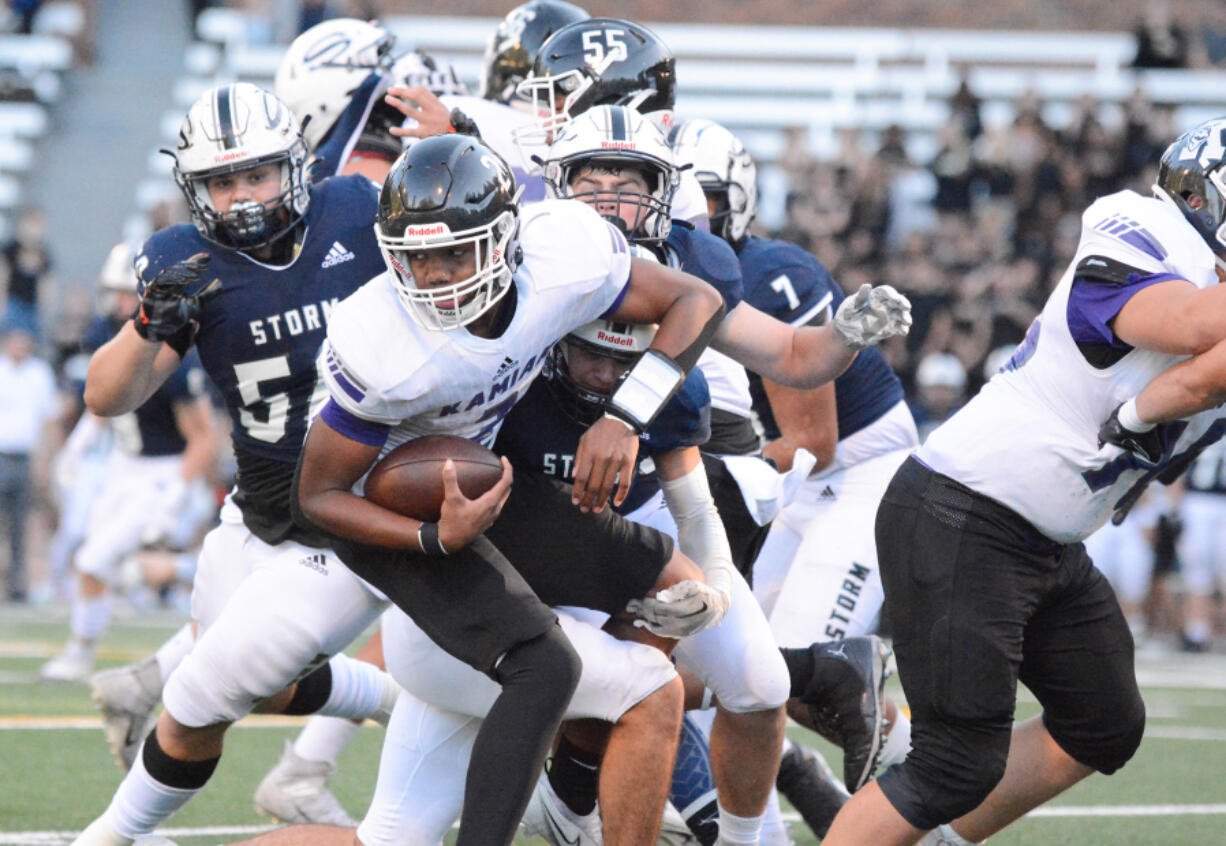 Skyview defenders Ty Evans, left, Kellen Wiggins, top right, and Cameron Crooks, bottom right, combine to make a tackle on Kamiak quarterback Ben'tre Worthy on Friday at Kiggins Bowl in Vancouver.