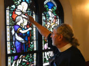 The Rev. Canon Dr. Mark Gatza, rector for Emmanuel Episcopal Church, talks about details in the glass as he explains the stories depicted in them during a tour of the church on Sept.