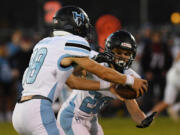 Hockinson's Jarod Oldham hands the ball off Jake McKee at Longview Memorial Stadium on Friday, September 23, in Longview.