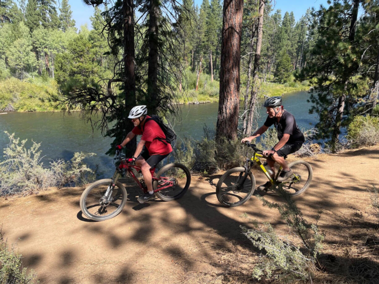 Mountain bikers cruise along the Deschutes River Trail just downstream of Benham Falls.