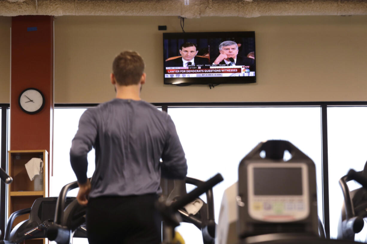 A gym club member runs on a treadmill and watches TV on Nov. 13, 2019, in Seattle. New data finds that gym memberships are still lagging behind their pre-pandemic numbers.