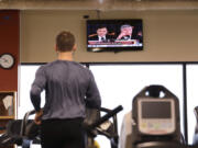 A gym club member runs on a treadmill and watches TV on Nov. 13, 2019, in Seattle. New data finds that gym memberships are still lagging behind their pre-pandemic numbers.