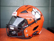 A new Battle Ground helmet sits on a wooden box Tuesday, Sept. 20, 2022, at Battle Ground High School. Ex-NFL player Michael Roos purchased custom-made Axiom helmets for a number of Tigers to wear. The helmets are designed for each player's specific head and include impact sensing and other technology for better safety.