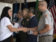 Victoria Prado, left, greets Aaron Ochoa, right, of Fort Vancouver National Historic Site, and others while celebrating her citizenship at Pearson Air Museum Historic Hangar on Thursday morning. Prado was one of 40 new U.S. citizens who participated in a naturalization ceremony at Fort Vancouver.