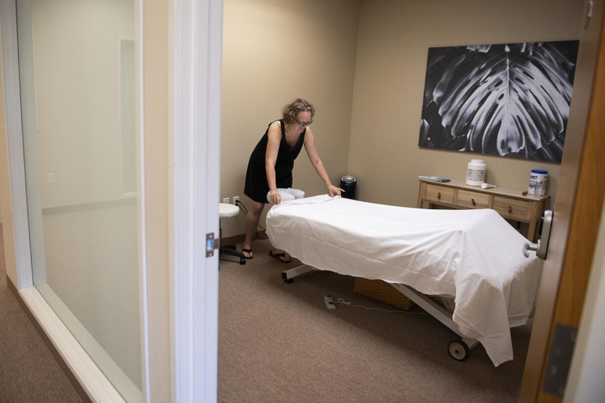 Massage therapist Jessica Sanchez-Harper prepares a therapy room for the next client at WellSpace in southeast Vancouver. "This really is invented," said Vince Williams, the company's co-owner and CEO. WellSpace uses a gymlike membership model to provide rentable treatment rooms for massage therapists.