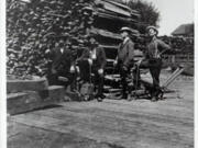 Vancouver was losing money on its first electricity generation plant when Joe Harvey offered to buy it in 1901 and run it as a regulated private utility company. He stands second from the right wearing a suit. On his right stands his older brother with a foot on the woodpile. As the Vancouver Electric Light and Power Company, they turned untold cords of wood into electricity to light the city.