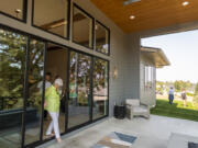 Michele Uplinger, left, of Ridgefield, steps onto the deck of the Oak View home at the GRO Parade of Homes in Ridgefield on Friday. The builder for Oak View is Glavin Homes. The home is named for the large oak tree in the backyard.