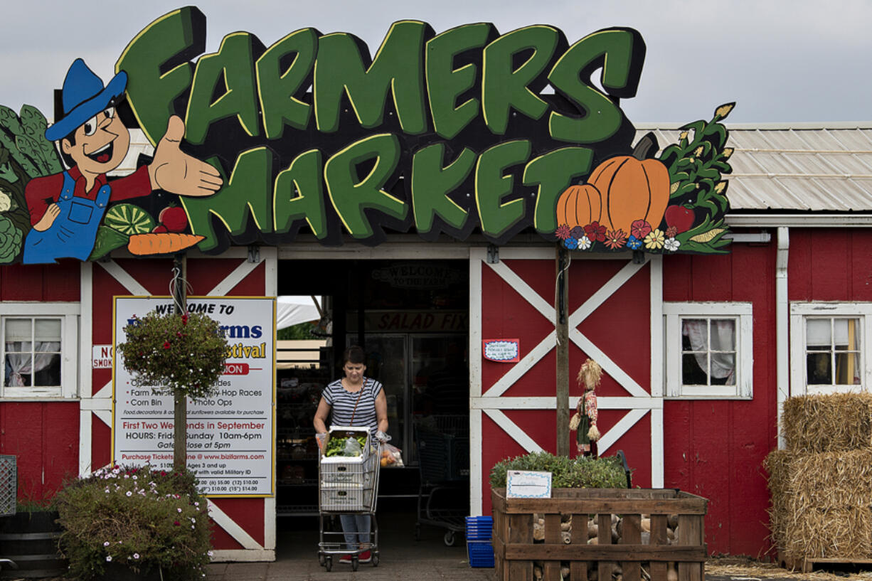 Shopper Lyubov Igumnov of Vancouver leaves Bi-Zi Farms with a cart full of fresh produce on Monday afternoon. The farm is gearing up to celebrate its 150th anniversary with an event on Sunday.