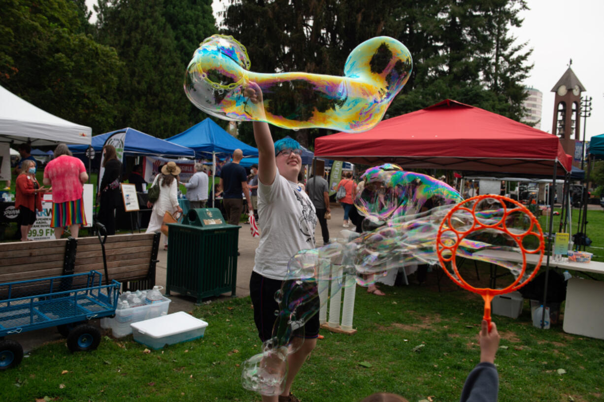 Rowen Whelchel, 13, of Vancouver makes enormous bubbles at the Columbia Play Project booth for children's science projects Saturday during the Peace and Justice Fair at Esther Short Park.