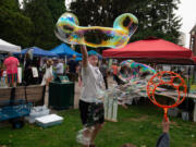 Rowen Whelchel, 13, of Vancouver makes enormous bubbles at the Columbia Play Project booth for children's science projects Saturday during the Peace and Justice Fair at Esther Short Park.