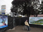 Hope Village resident Jimmy John Howland sits by his favorite mural at Hope Village, the city's second Safe Stay Community. The mountainous landscape featured in the mural reminds him of Trillium Lake, where he used to go with his dad when he was younger.