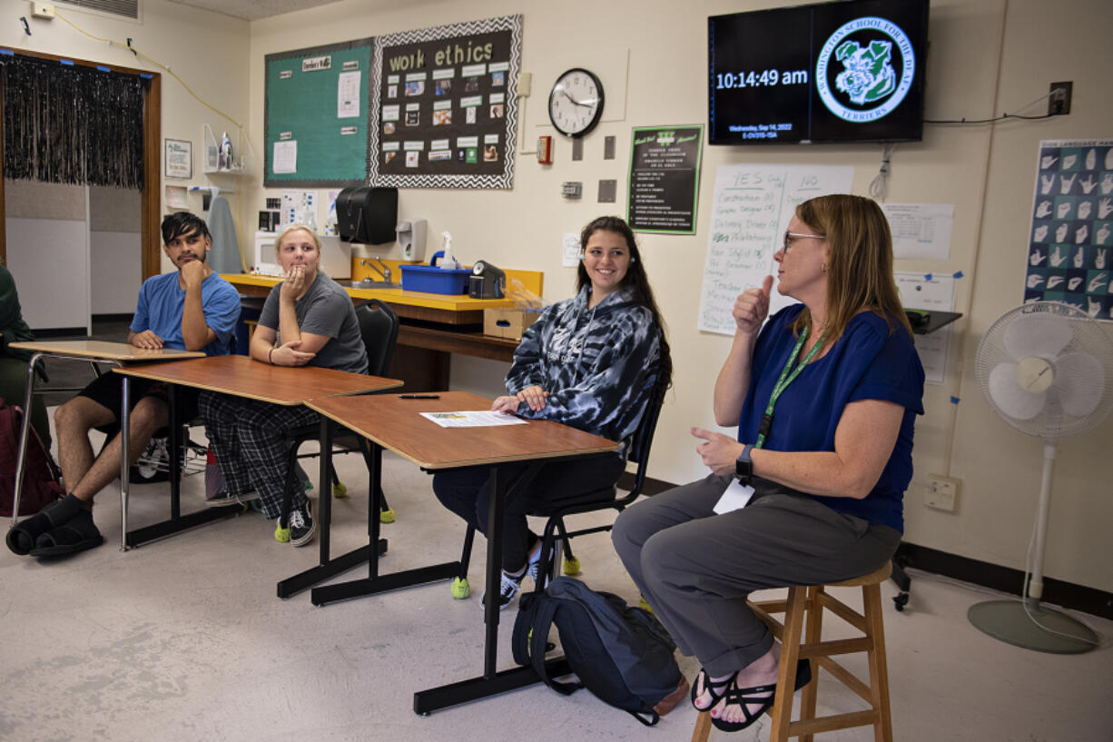 From left: Students Tye Gonzalez-Woodbury, Briyana Moore and Ashley Andersen join teacher Dana Miles, in blue, the 2023 Washington State Teacher of the Year, during their advisory period at the Washington School for the Deaf on Wednesday morning. Miles teaches bilingual English language arts at the Vancouver school.