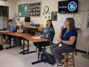 From left: Students Tye Gonzalez-Woodbury, Briyana Moore and Ashley Andersen join teacher Dana Miles, in blue, the 2023 Washington State Teacher of the Year, during their advisory period at the Washington School for the Deaf on Wednesday morning. Miles teaches bilingual English language arts at the Vancouver school.