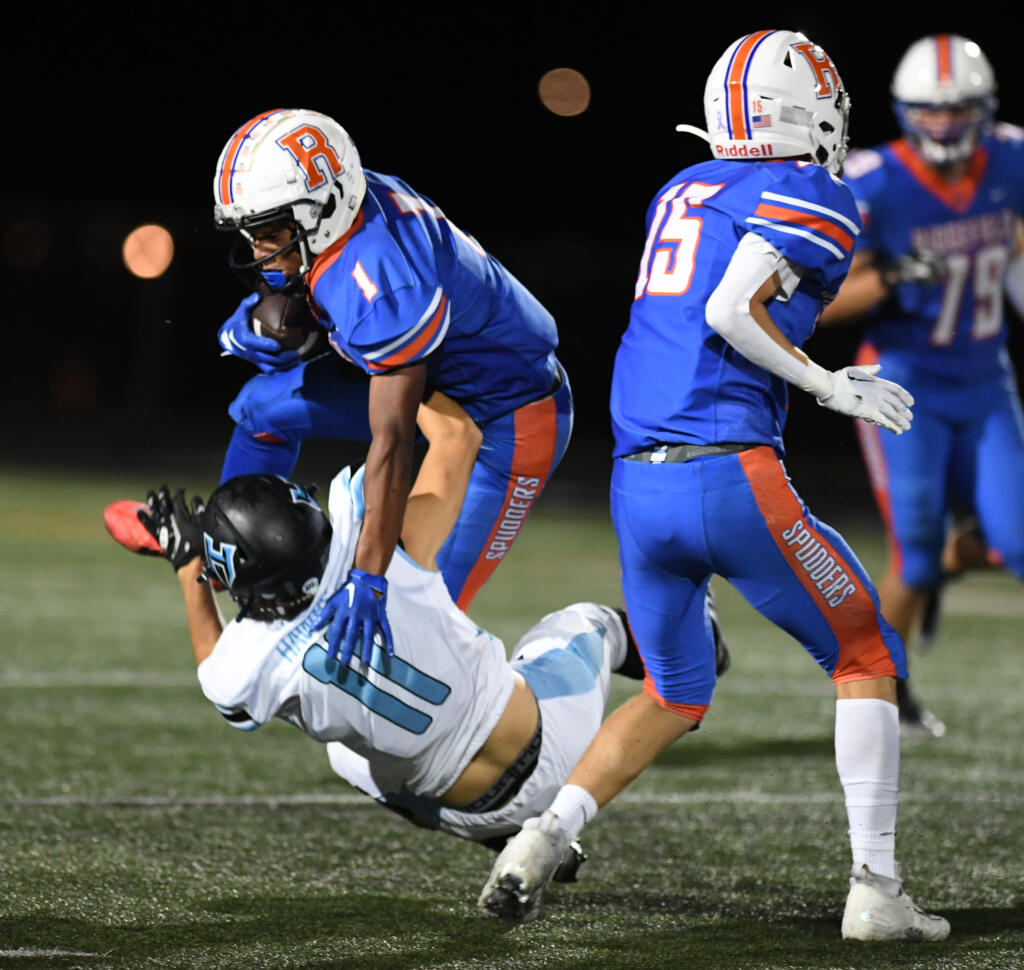 Ridgefield senior Isaiah Cowley (1) runs over Hockinson sophomore Zachary Chung on Friday, Sept. 16, 2022, during Ridgefield’s 26-21 win against Hockinson at Ridgefield High School.