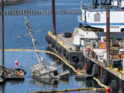 A partially submerged boat sticks out of the Columbia River on Tuesday, Sept. 20, 2022, as seen from the I-5 Bridge near Hayden Island. Crews are working on removing the vessel.