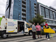 Megan Whetsell, left, and Erek Watson, both of Vancouver, chat with Jeanne Bennett of Columbia Play Project, dressed as "Doug the Slug," as she hands out flyers during Give More24! at The Waterfront Vancouver in September.