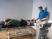 Ridgefield resident Anna Presley, left, gets treatment for a soccer injury from physical therapist Mike Teater at FYZICAL Therapy & Balance Center of Camas.