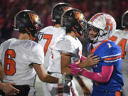 Ridgefield senior Isaiah Cowley, right, congratulates Washougal players on a good game Friday, Sept. 30, 2022, after the Spudders’ 34-27 loss to Washougal at Ridgefield High School.