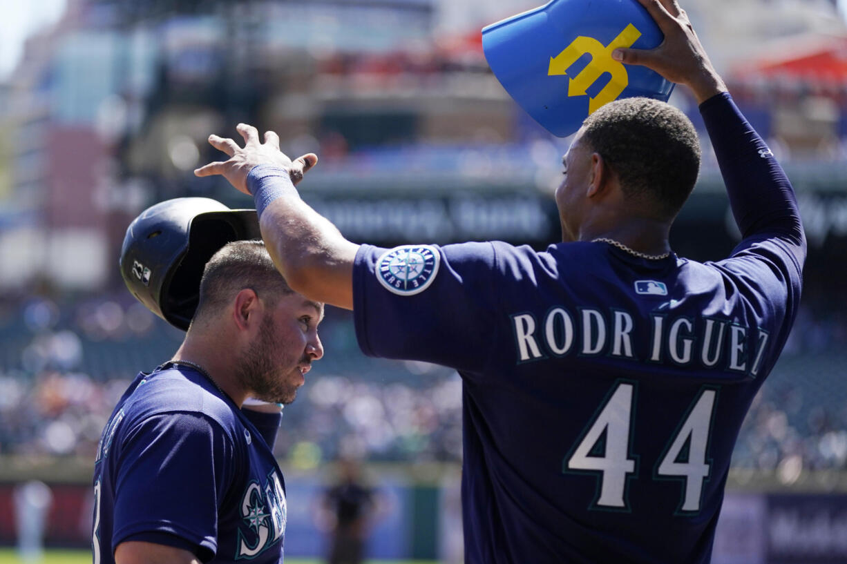 Seattle Mariners' Julio Rodriguez puts the home run helmet on Ty France after a solo home run during the third inning of a baseball game against the Detroit Tigers, Thursday, Sept. 1, 2022, in Detroit.