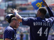 Seattle Mariners' Julio Rodriguez puts the home run helmet on Ty France after a solo home run during the third inning of a baseball game against the Detroit Tigers, Thursday, Sept. 1, 2022, in Detroit.