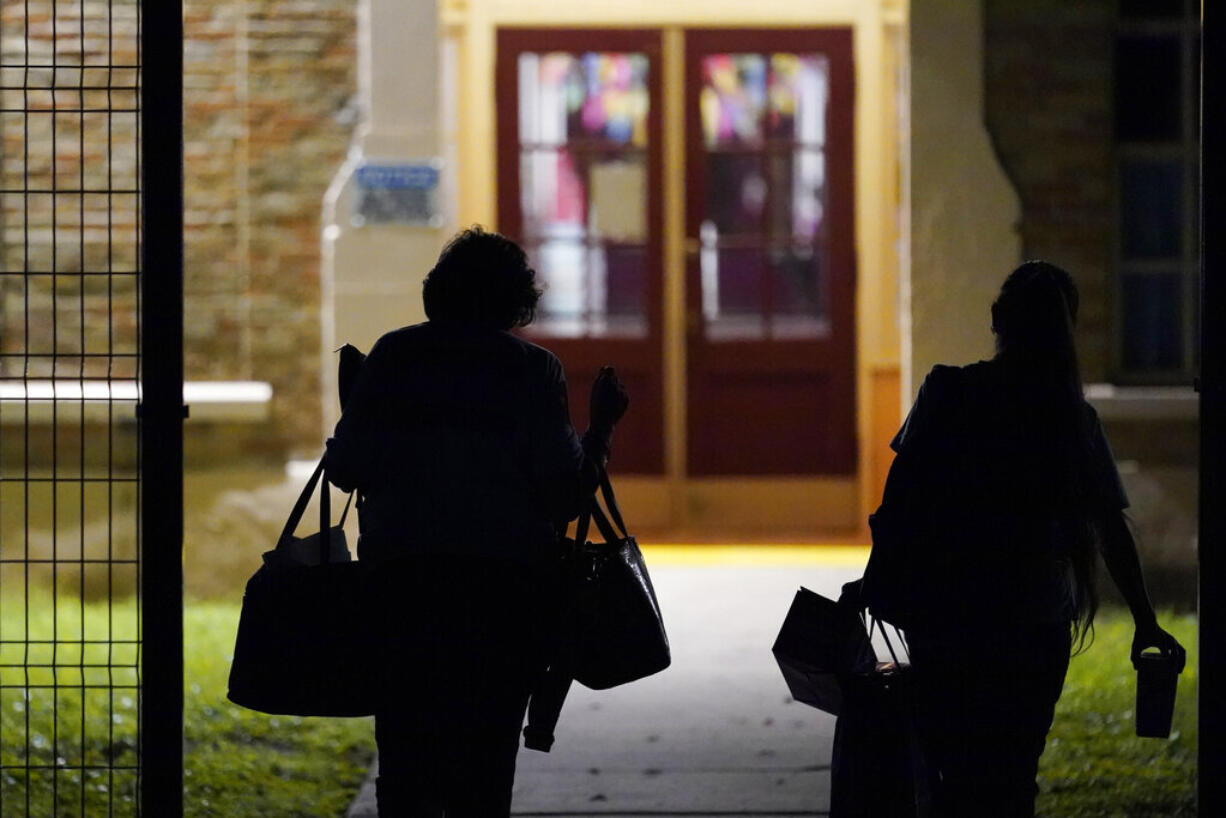 Teachers walk through the gate of a new fence as they arrive at Uvalde Elementary for the first day of school, Tuesday, Sept. 6, 2022, in Uvalde. Students in Uvalde are returning to campuses for the first time since the shootings at Robb Elementary where two teachers and 19 students were killed.