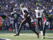 Atlanta Falcons wide receiver Drake London, center, scores a touchdown during the second half of an NFL football game against the Atlanta Falcons, Sunday, Sept. 25, 2022, in Seattle.