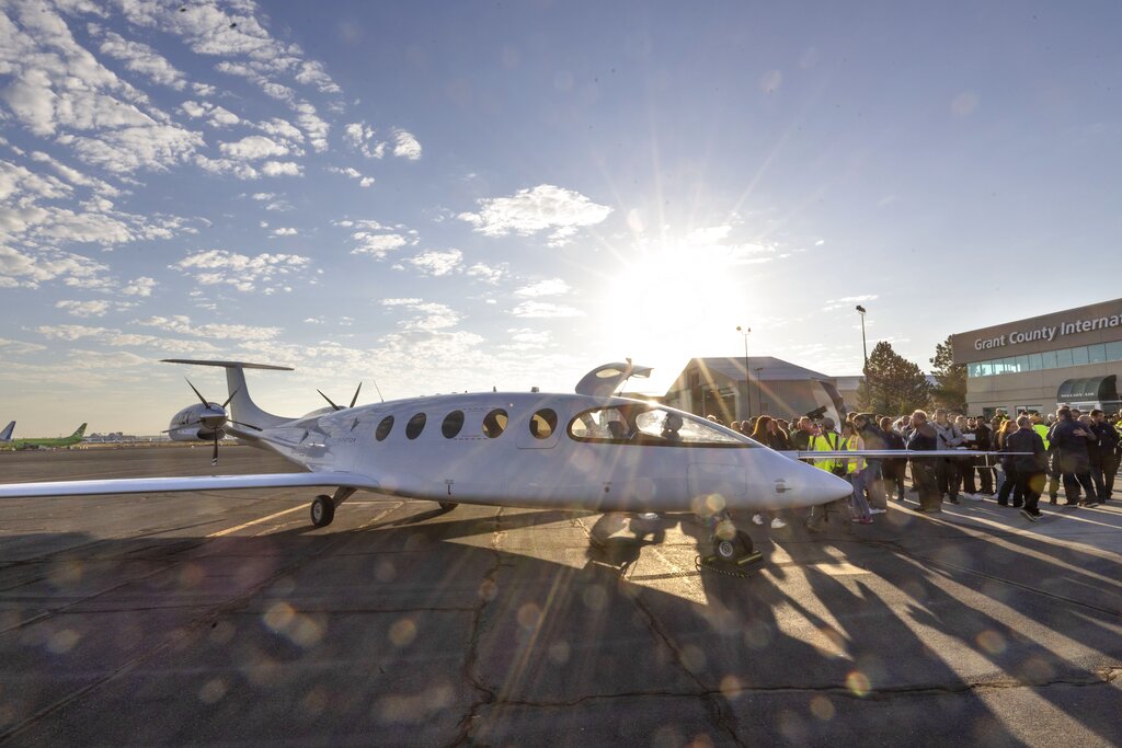 A crowd gathers around Alice, an all-electric airplane designed and built by Eviation, on the tarmac in Moses Lake, Wash., after taking its first flight Tuesday, Sept. 27, 2022. (Ellen M.