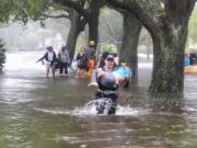 In this photo provided by Orange County Fire Rescue's Public Information Office, firefighters in Orange County, Fla., help people stranded by Hurricane Ian early Thursday, Sept. 29, 2022. Ian marched across central Florida on Thursday as a tropical storm after battering the state’s southwest coast, dropping heavy rains that caused flooding and led to inland rescues and evacuations.