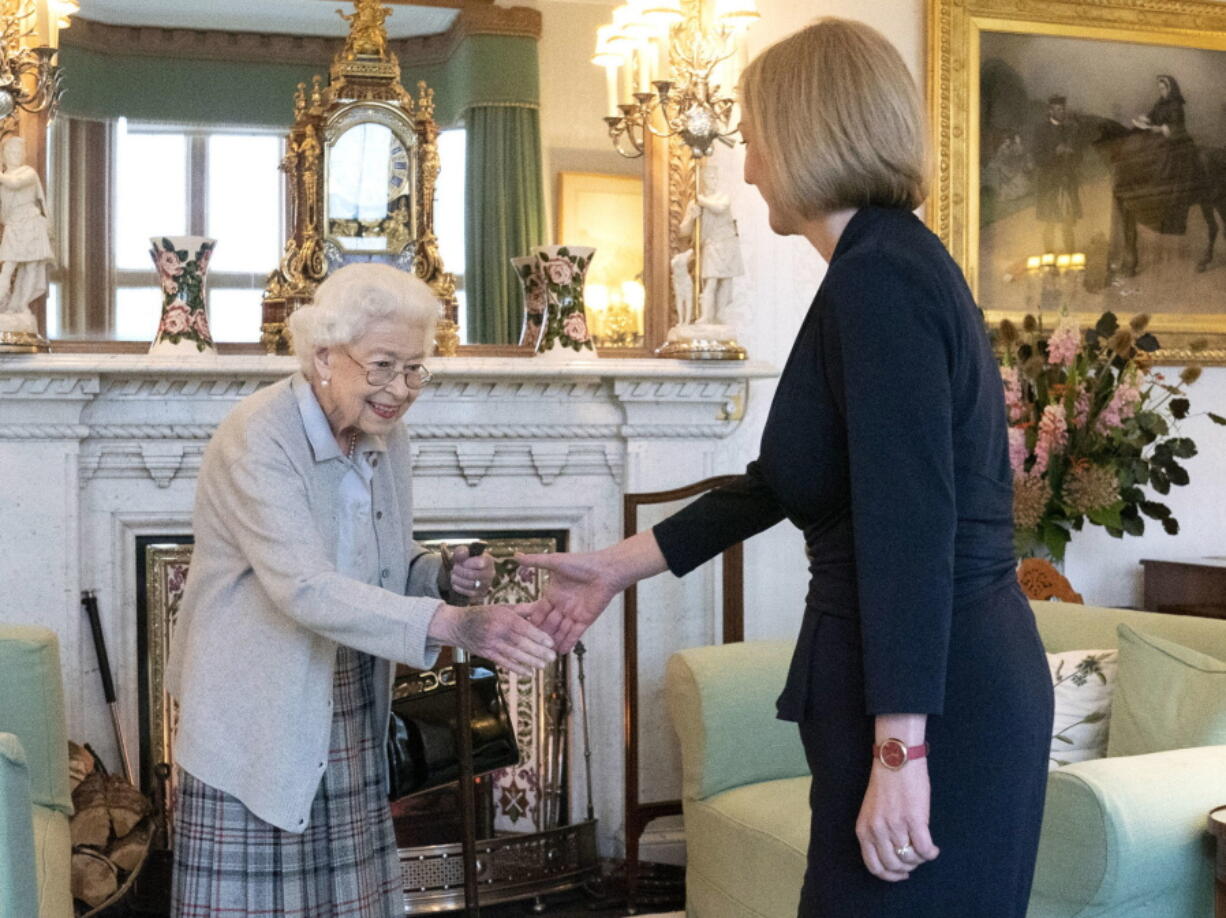 Britain's Queen Elizabeth II, left, welcomes Liz Truss during an audience at Balmoral, Scotland, where she invited the newly elected leader of the Conservative party to become Prime Minister and form a new government, Tuesday, Sept. 6, 2022.