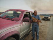 Rick Fitzpatrick holds a dog after evacuating from the Fairview Fire Monday, Sept. 5, 2022, near Hemet, Calif.