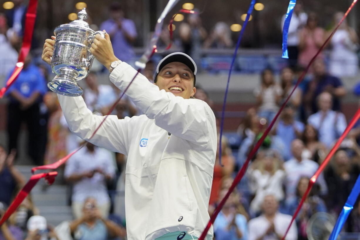 Iga Swiatek, of Poland, holds up the championship trophy after defeating Ons Jabeur, of Tunisia, to win the women's singles final of the U.S. Open tennis championships, Saturday, Sept. 10, 2022, in New York.