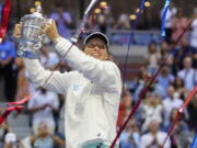 Iga Swiatek, of Poland, holds up the championship trophy after defeating Ons Jabeur, of Tunisia, to win the women's singles final of the U.S. Open tennis championships, Saturday, Sept. 10, 2022, in New York.