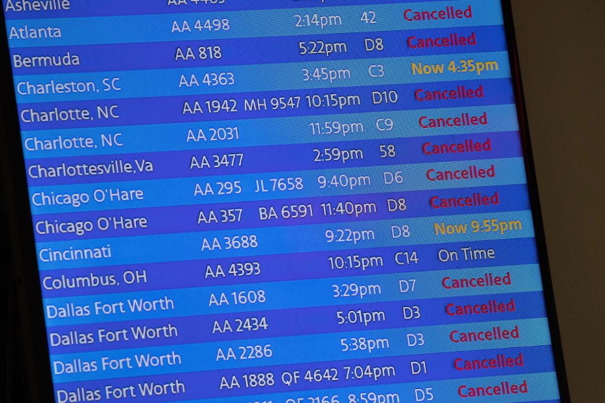 FILE - The arrivals board at the American Airlines terminal at LaGuardia Airport displays the flights that have been canceled or delayed and one that is on time, March 21, 2020, in New York. Flight delays and cancellations have bedeviled airline travel so far this year. The Transportation Department is launching a customer service dashboard to assist vacationers ahead of the travel-heavy Labor Day weekend.