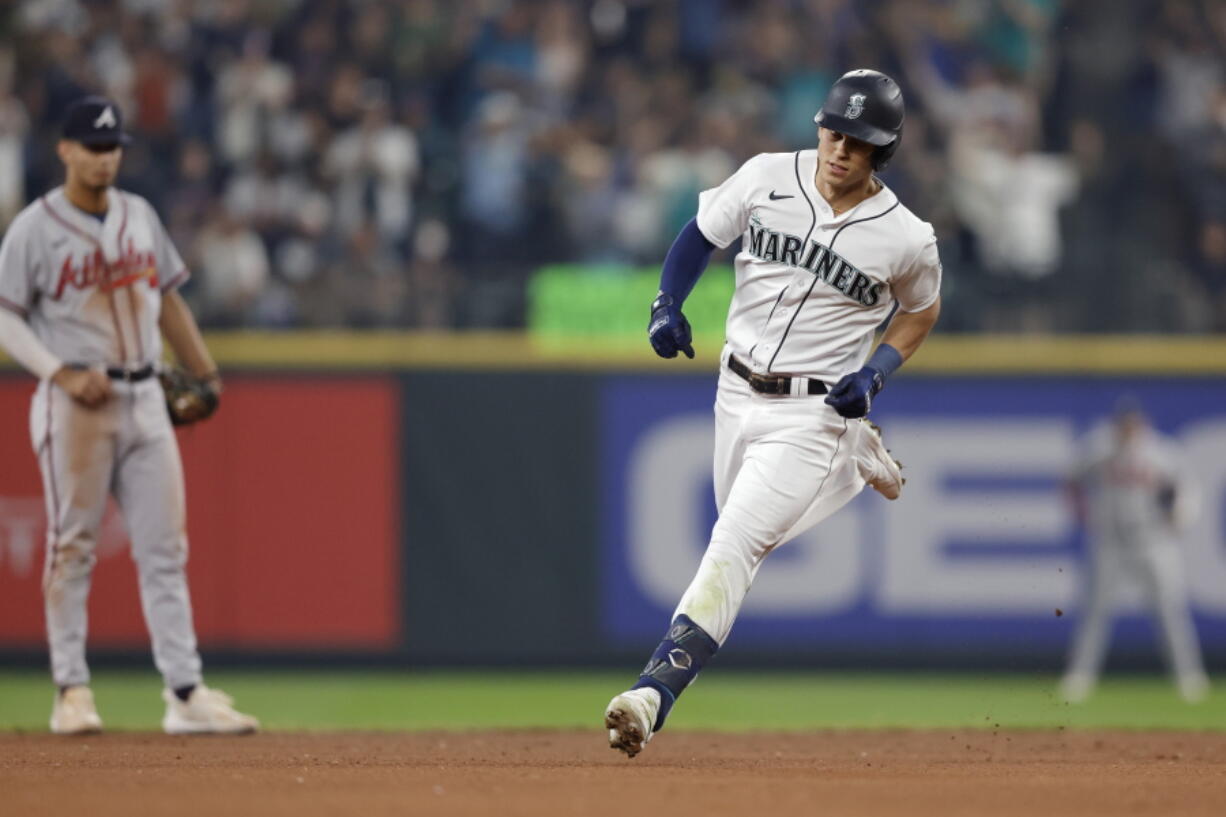 Seattle Mariners' Sam Haggerty, right, rounds the bases after hitting a solo home run on a pitch from Atlanta Braves starting pitcher Max Fried during the fifth inning of a baseball game, Saturday, Sept. 10, 2022, in Seattle.