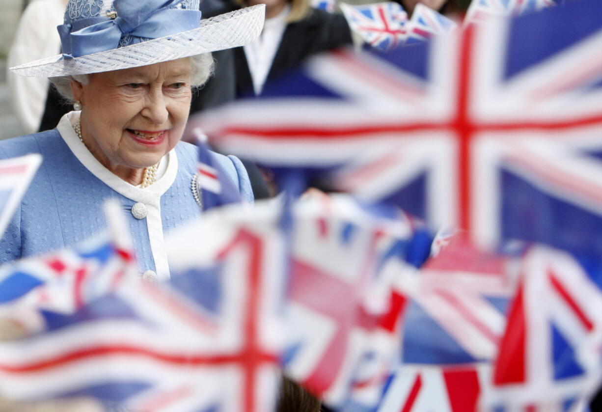 FILE - In this Tuesday, June 21, 2011 file photo, schoolchildren wave Union flags as Britain's Queen Elizabeth II leaves St Paul's Cathedral in London after attending a service to celebrate its Tercentenary. Queen Elizabeth II, Britain's longest-reigning monarch and a rock of stability across much of a turbulent century, has died. She was 96. Buckingham Palace made the announcement in a statement on Thursday Sept. 8, 2022.