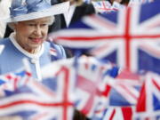 FILE - In this Tuesday, June 21, 2011 file photo, schoolchildren wave Union flags as Britain's Queen Elizabeth II leaves St Paul's Cathedral in London after attending a service to celebrate its Tercentenary. Queen Elizabeth II, Britain's longest-reigning monarch and a rock of stability across much of a turbulent century, has died. She was 96. Buckingham Palace made the announcement in a statement on Thursday Sept. 8, 2022.