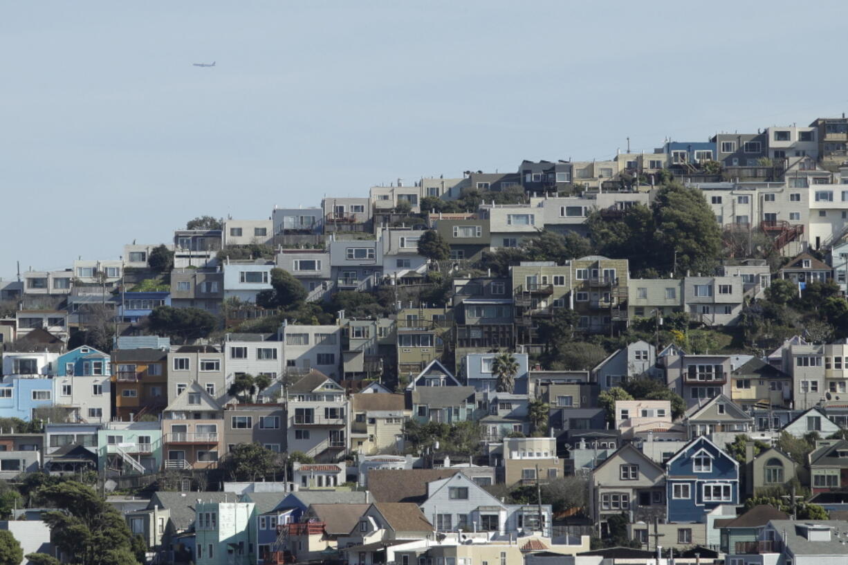 FILE - A plane flies over homes and residential buildings in San Francisco, Wednesday, March 4, 2020. California lawmakers have reached a deal on a pair of housing production bills. The bills would open up much of the state's commercial land for residential development. California has a housing shortage.