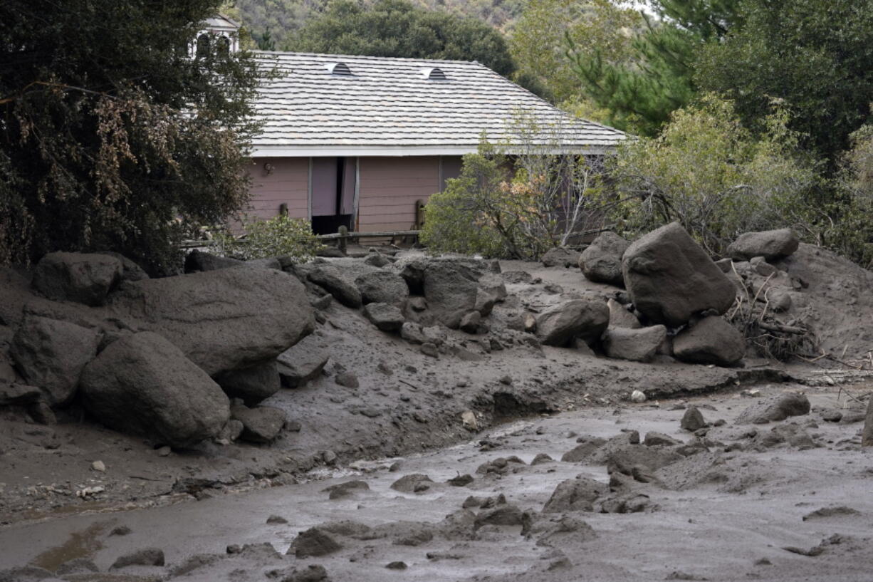 The front yard of a property is covered in mud in the aftermath of a mudslide Tuesday, Sept. 13, 2022, in Oak Glen, Calif. Cleanup efforts and damage assessments are underway east of Los Angeles after heavy rains unleashed mudslides in a mountain area scorched by a wildfire two years ago.