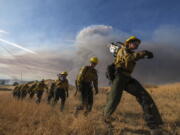 Firefighters walk in a line during a wildfire in Castaic, Calif. on Wednesday, Aug. 31, 2022. (AP Photo/Ringo H.W.