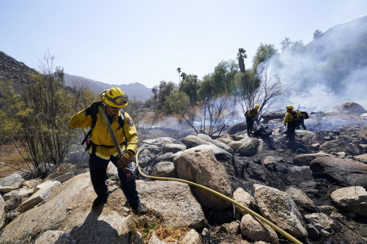 Cal Fire crews work a flare up near the Barrett Mobile Home and RV Park as they fight the Border Fire Thursday, Sept. 1, 2022, in Dulzura, Calif. California wildfires chewed through rural areas north of Los Angeles and east of San Diego on Thursday, racing through bone-dry brush and prompting evacuations as the state sweltered under a heat wave that could last through Labor Day.