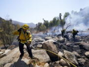 Cal Fire crews work a flare up near the Barrett Mobile Home and RV Park as they fight the Border Fire Thursday, Sept. 1, 2022, in Dulzura, Calif. California wildfires chewed through rural areas north of Los Angeles and east of San Diego on Thursday, racing through bone-dry brush and prompting evacuations as the state sweltered under a heat wave that could last through Labor Day.