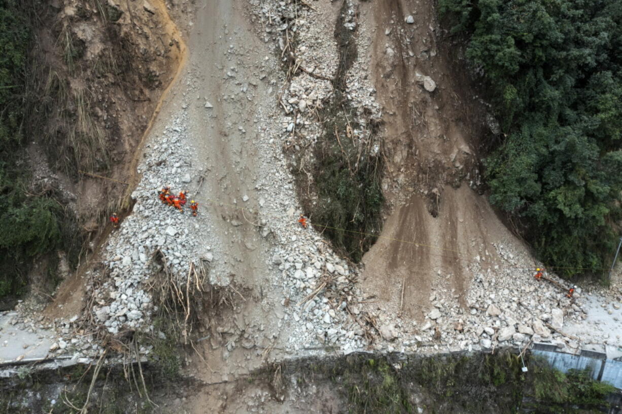 In this photo released by Xinhua News Agency, rescuers transfer an earthquake affected villager through a damaged mountain road near Moxi Town of Luding County, southwest China's Sichuan Province Wednesday, Sept. 7, 2022. The death toll in this week's earthquake in western China has jumped to more than dozen with plenty still missing, the government reported Wednesday, as frustration rose with uncompromising COVID-19 lockdown measures that prevented residents from leaving their buildings after the shaking.