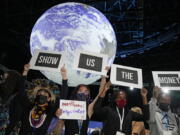 FILE - Climate activist Vanessa Nakate, second right, and other activists engage in a 'Show US The Money' protest at the COP26 U.N. Climate Summit in Glasgow, Scotland, Nov. 8, 2021. From drought to cyclones and sea level rise, the cost of damage caused by climate change in Africa will only get higher as the world warms, stirring concerns from activists and officials about how to pay for it.