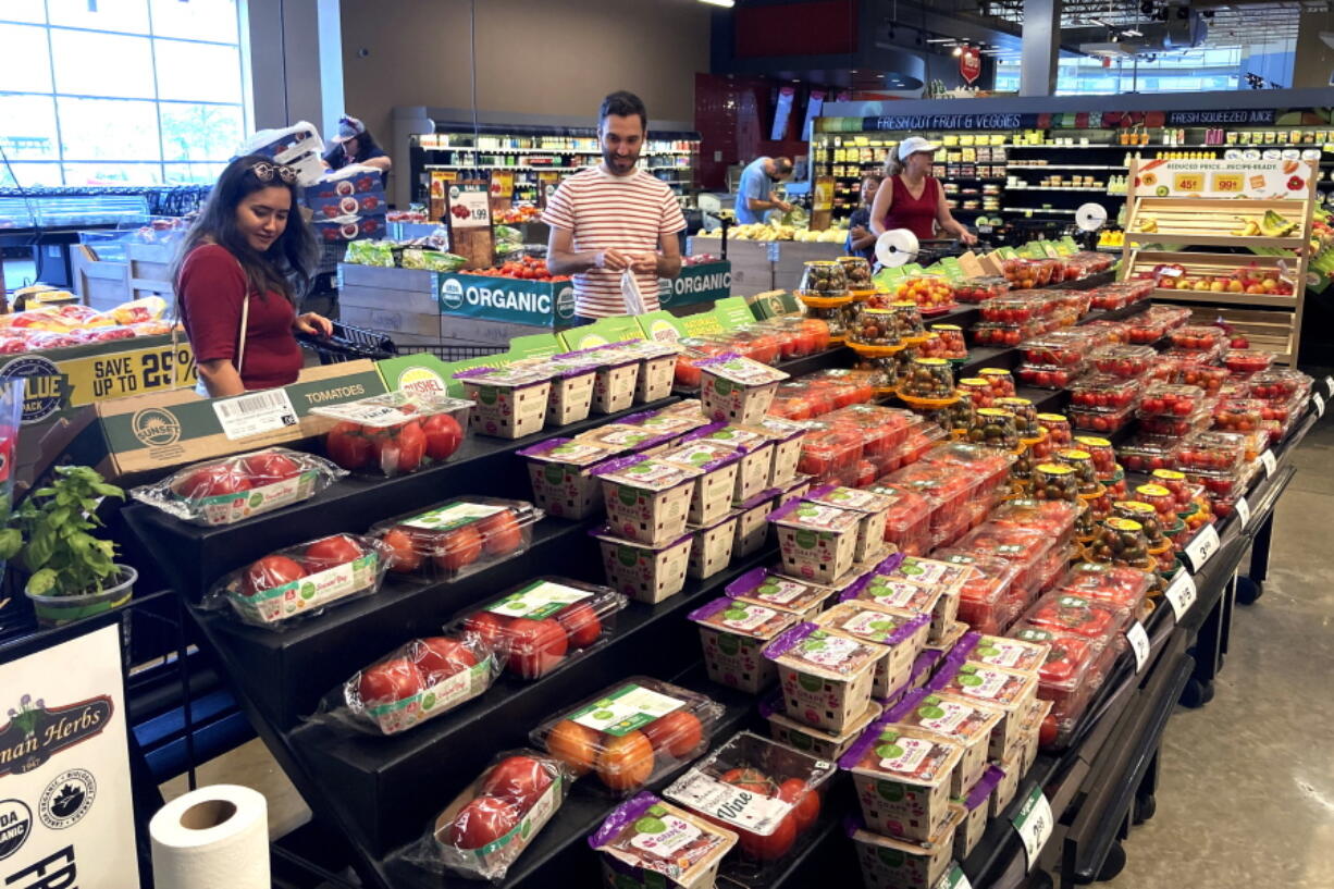 Shoppers shop at a grocery store in Glenview, Ill., Monday, July 4, 2022. Consumers spent a bit more in August than the previous month, a sign the economy is holding up even as inflation lifts prices for food, rent, and other essentials. Americans boosted their spending at stores and for services such as haircuts by 0.4% in August, after it fell 0.2% in July, the Commerce Department said Friday Sept. 30.    (AP Photo/Nam Y.