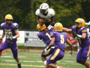 Skyview running back Trey Jacob (3) attempts to hurdle over Columbia River defender Joseph Pena (1) on Saturday at Kiggins Bowl in Vancouver.