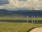 Clouds cast shadows near wind turbines at a wind farm along the Montana-Wyoming state line on Monday, June 13, 2022. The rush to build wind farms to combat climate change is colliding with preservation of one of the U.S. West's most spectacular predators, the golden eagle. Scientists say the species is teetering on the edge of decline and worry that proliferating wind turbines could push them over the brink. (AP Photo/Emma H.