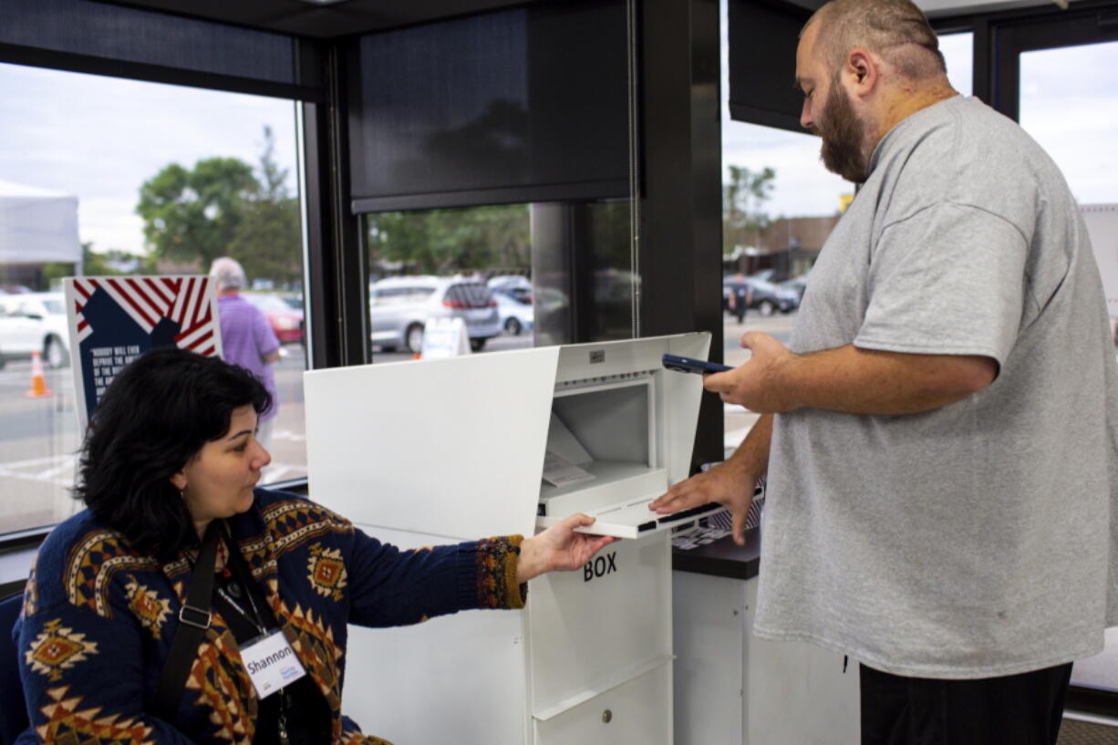 Conrad Zbikowski places his ballot in the ballot box on Friday, Sept. 23, 2022, in Minneapolis. With Election Day still more than six weeks off, the first votes of the midterm election were already being cast Friday in a smattering of states including Minnesota.